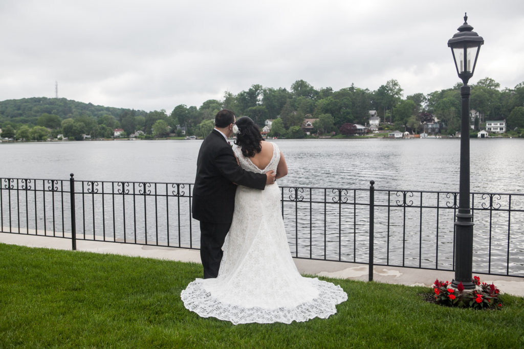 Wedding couple embracing and staring out onto a lake
